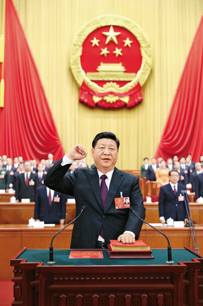 2018年3月17日，十三屆全國人大一次會議在北京人民大會堂舉行第五次全體會議。習近平當選中華人民共和國主席、中華人民共和國中央軍事委員會主席。這是習近平進行憲法宣誓。 新華社記者 鞠鵬/攝